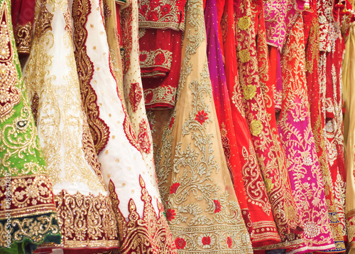 Close up colorful and shinny Indian bridal weeding dress in a shop. Female party clothes.
