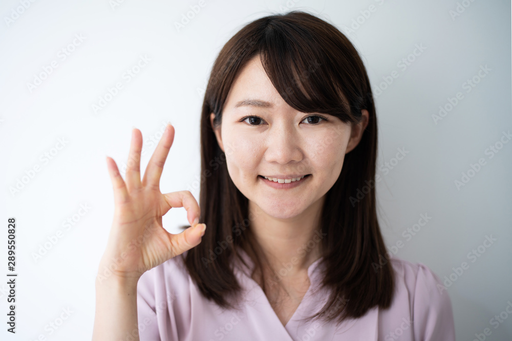 Young business woman showing OK sign againt white background Young business woman showing OK sign againt white background