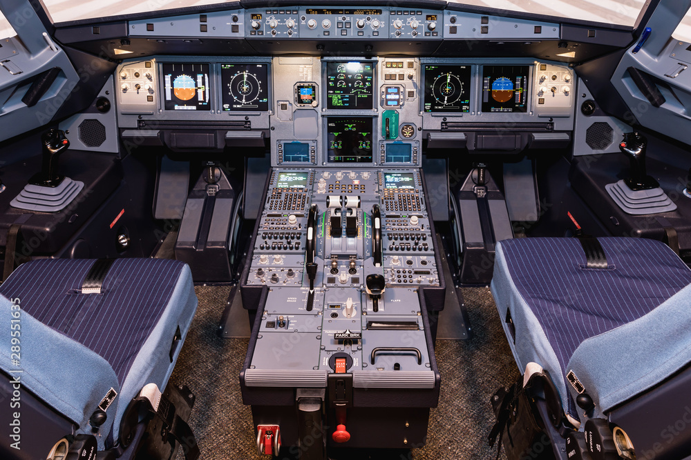 Cockpit of airliner simulator. Switches and dials visible in the background. - obrazy, fototapety, plakaty 