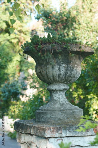  old vase on an old brick pedestal in a city park