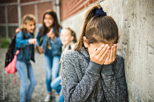 A sad girl intimidation moment on the elementary Age Bullying in Schoolyard photo