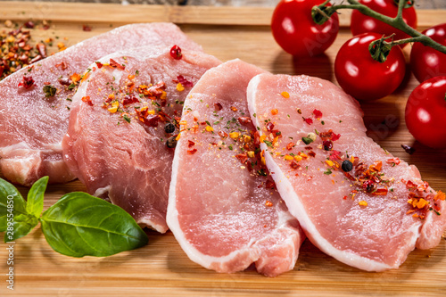 Raw pork chops on cutting board