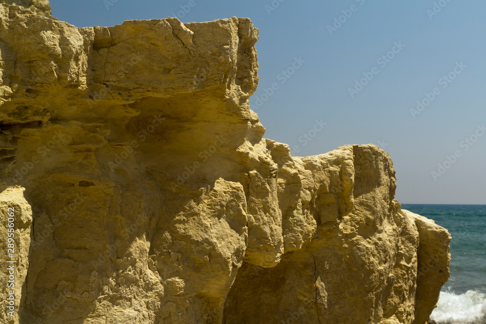 Yellow sea cliff in front of blue sky