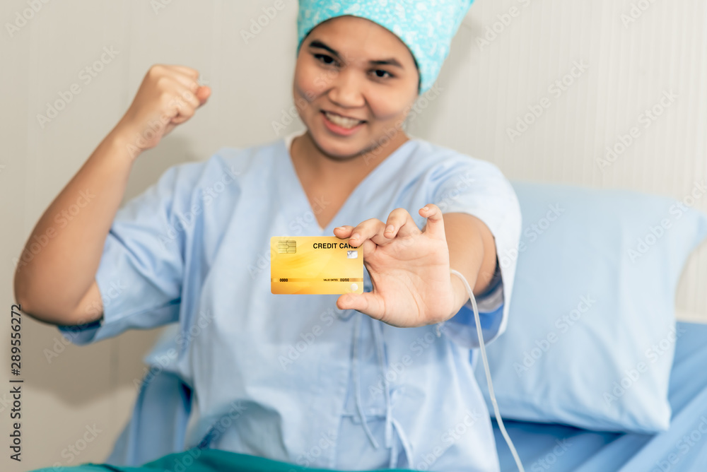 Asian female patients sitting in a patient bed Show mock up credit card Which is held in her hand, to health care and insurance concept. Asian female patients sitting in a patient bed Show mock up credit card Which is held in her hand, to health care and insurance concept.