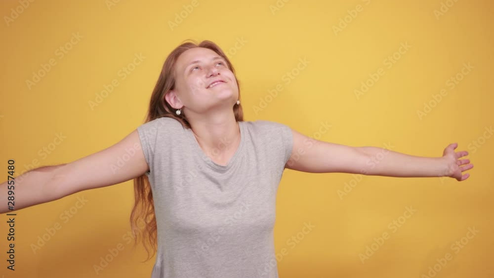 brunette girl in gray t-shirt over isolated orange background shows emotions brunette girl in gray t-shirt over isolated orange background shows emotions