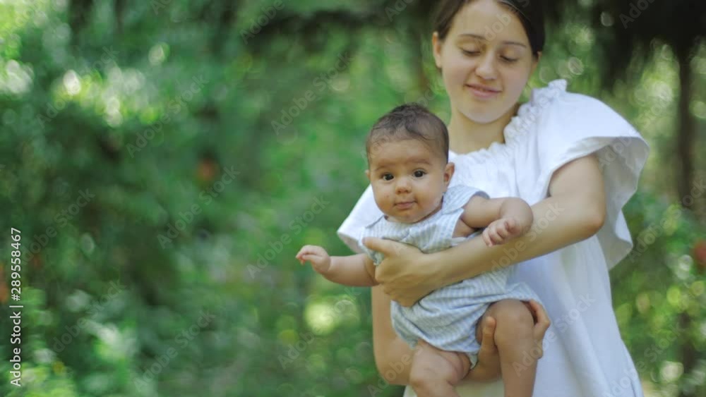 Mother with her newborn daughter on a green grass in a park. Happy young Mother and Child enjoying nature. Mother with her newborn daughter on a green grass in a park. Happy young Mother and Child enjoying nature.