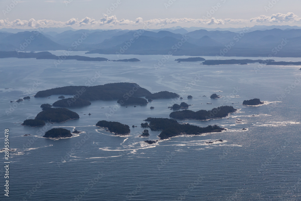 Obraz premium Aerial Landscape View of Beautiful Pacific Ocean Coast with Coastal Mountains at the background during a summer morning. Taken near Tofino and Ucluelet, Vancouver Island, British Columbia, Canada.