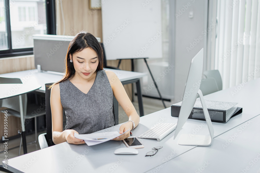 Concentrated young business woman working on her computer in the office.,standing on workplace. Concentrated young business woman working on her computer in the office.,standing on workplace.