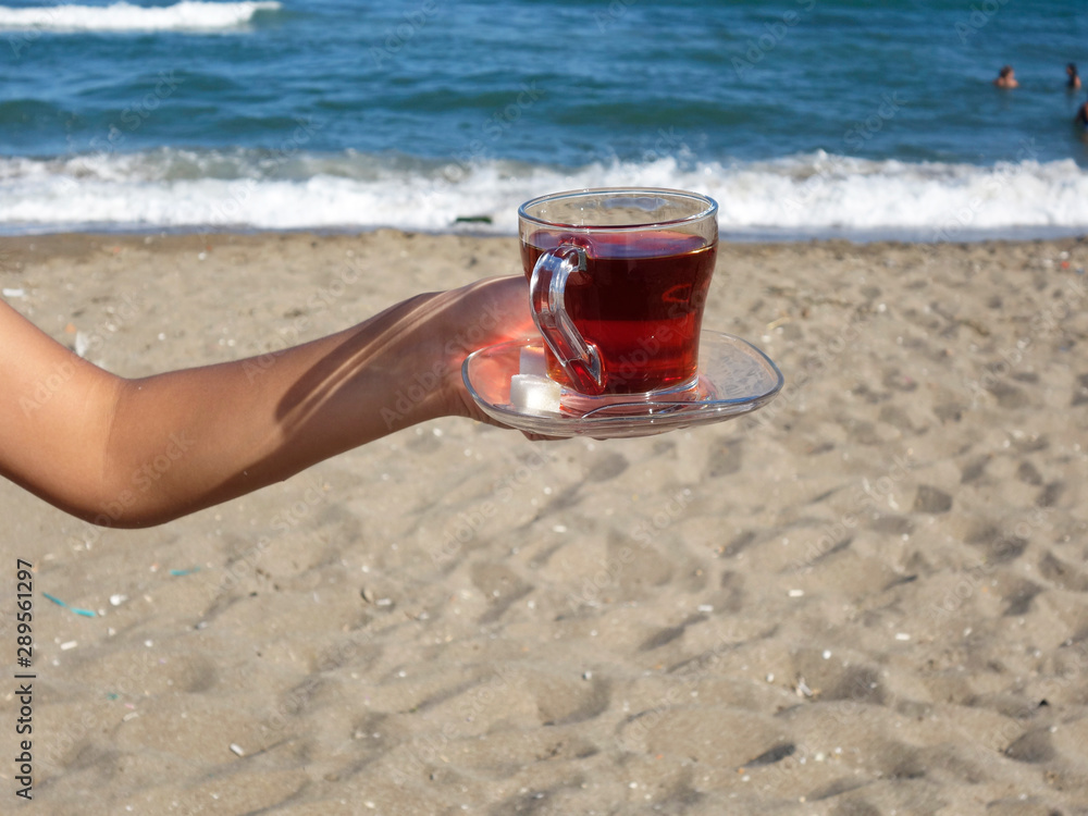 lady holding a cup of tea on the beach lady holding a cup of tea on the beach