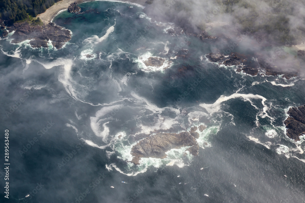 Aerial View from Above of a beautiful beach covered in Clouds and Fog at the West Pacific Ocean Coast. Taken near Tofino and Ucluelet in Vancouver Island, BC, Canada.