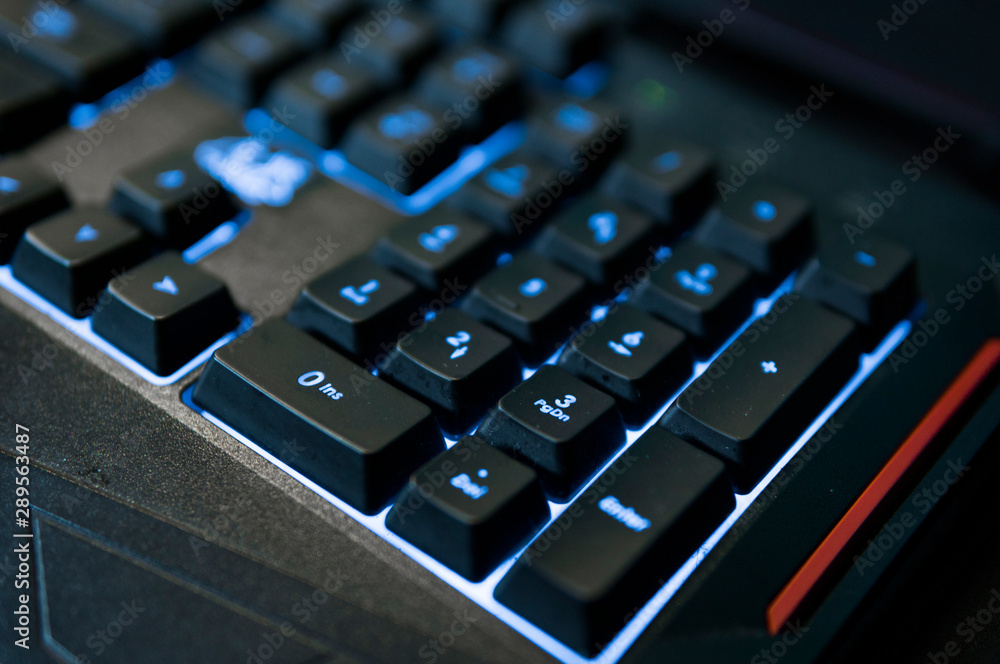 Gamer keyboard with colorful blue lights, modern gamer computer. Blue backlight, backlit on laptop or keyborad computer of gaming.