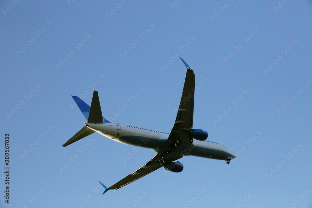 Closeup Beautiful Airplane in a blue clear sky. The plane takes off or lands for landing. Air passenger transport. Closeup Beautiful Airplane in a blue clear sky. The plane takes off or lands for landing. Air passenger transport.