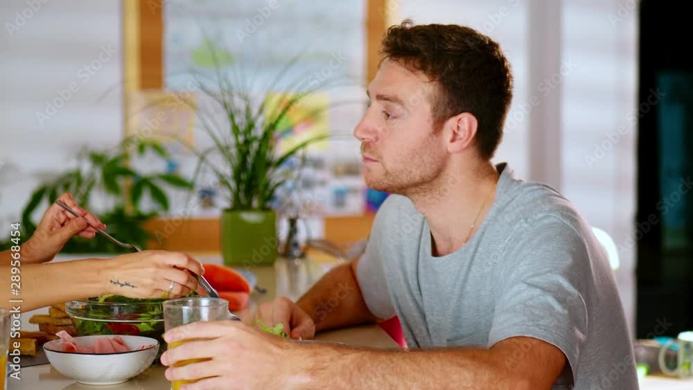 Cheerful young woman caring putting salad on plates during Sunday morning breakfast, glass of fresh tasty orange juice on kitchen table cozy kitchen couple chatting about domestic with boyfriend Cheerful young woman caring putting salad on plates during Sunday morning breakfast, glass of fresh tasty orange juice on kitchen table cozy kitchen couple chatting about domestic with boyfriend