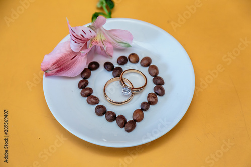 Coffee, flowers and wedding rings. Close-up.