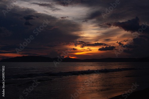 Sunset at the beach scenery with sea view, clouds, and waves. Nature beauty composition.