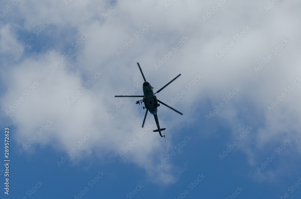 Silhouette of a flying helicopter in the sky.