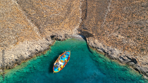 Aerial drone photo of traditional fishing boat docked in paradise beach of Kaminakia with emerald clear sea, Astypalaia island, Dodecanese, Greece