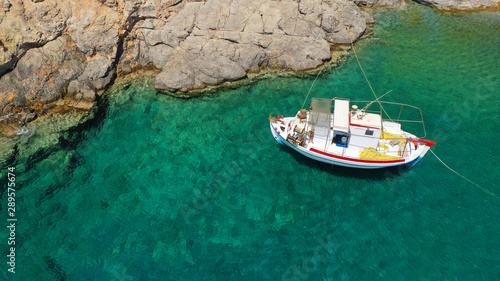 Aerial drone photo of traditional fishing boat docked in paradise beach of Kaminakia with emerald clear sea, Astypalaia island, Dodecanese, Greece