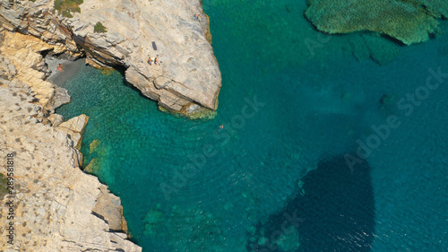 Aerial drone photo of paradise small beach of Mouros with caves and crystal clear sea, Amorgos island, Cyclades, Greece