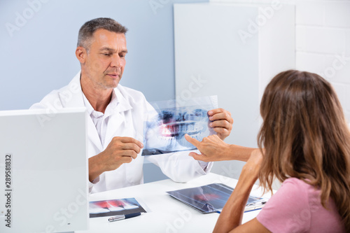 Doctor Showing Dental X-ray In Clinic