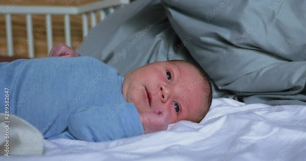 Newborn Baby Lying Awake in Bed Newborn Baby Lying Awake in Bed