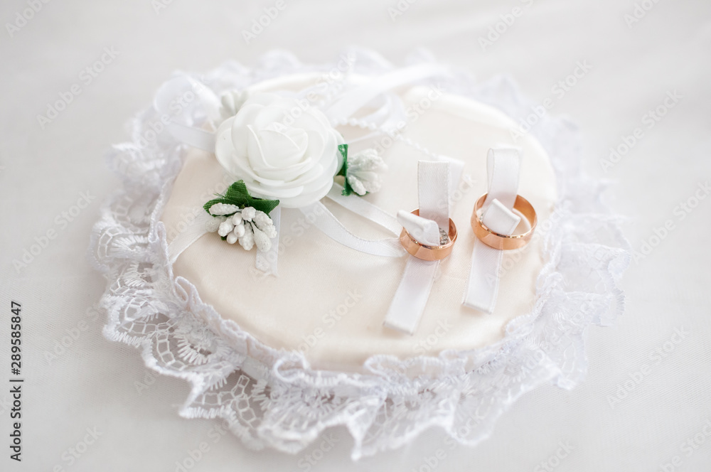 Couple of gold wedding rings on the white pad Couple of gold wedding rings on the white pad