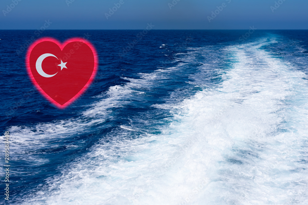 Fototapeta premium Heart shaped turkish flag on background made of view of deep blue Mediterranian sea with kelvou jet, bubbles and waves