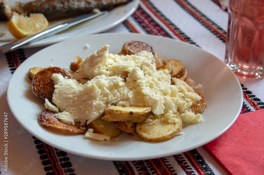 Roasted potatoes with local salt cheese prepared in local national Ukrainian restaurant, Carpathian region, Ukraine