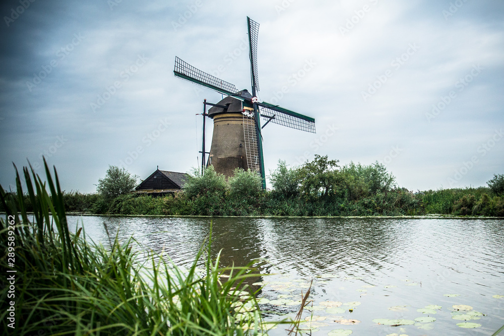 Naklejka premium Dutch windmill and surrounding landscape at Kinderdijk in Netherlands 