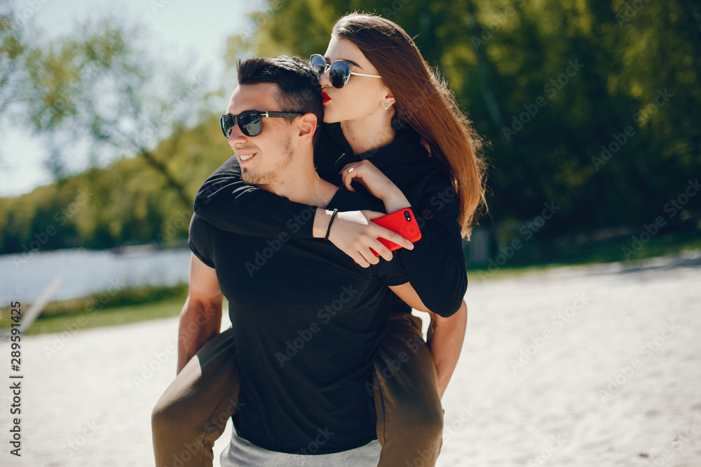 A stylish and bright love couple walks on the sunny beach A stylish and bright love couple walks on the sunny beach