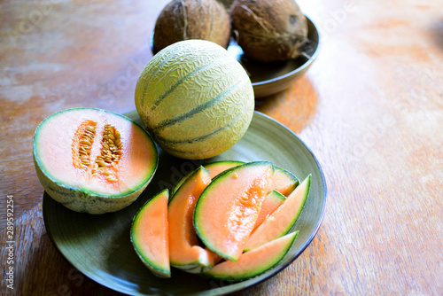 Ripe melon with orange color flesh and coconuts.