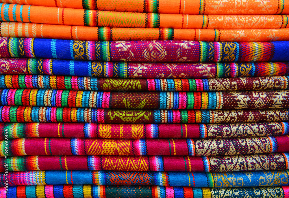 A pile of colorful traditional textiles in the Andes mountain range sunday market of Otavalo, north of Quito, Ecuador. A pile of colorful traditional textiles in the Andes mountain range sunday market of Otavalo, north of Quito, Ecuador.