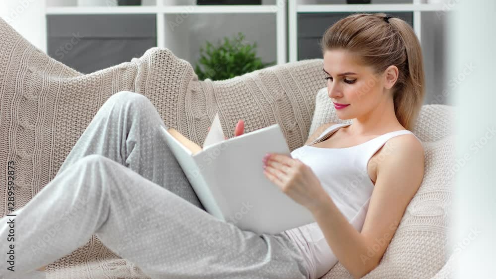Beautiful calmness female plaid reading book at comfortable home interior medium shot Beautiful calmness female plaid reading book at comfortable home interior medium shot