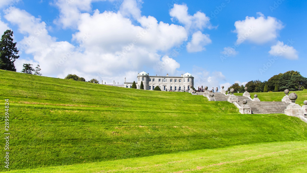 Tourists visiting Powerscourt Gardens one of the most beautiful gardens in Ireland view on mansion from terraced lawn