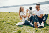 tender and merry lovers are having a good time at the lake with dog
