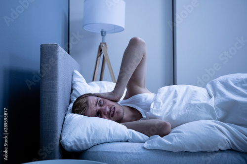 Man Covering His Head With Pillow