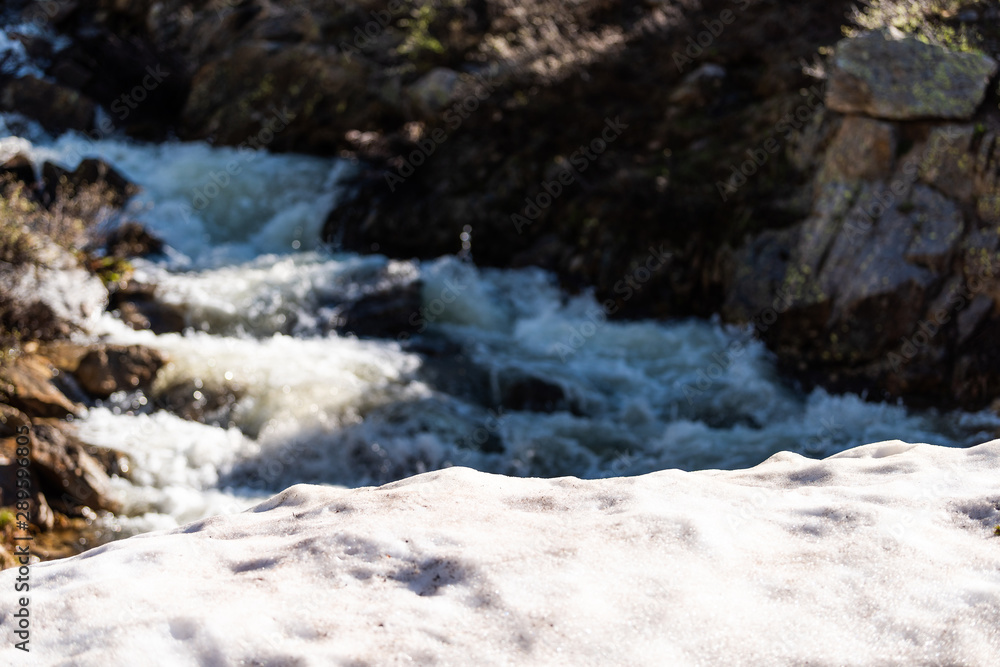 Closeup view of snow by river melting at Linkins Lake trail on Independence Pass in rocky mountains near Aspen, Colorado in early summer of 2019 Closeup view of snow by river melting at Linkins Lake trail on Independence Pass in rocky mountains near Aspen, Colorado in early summer of 2019