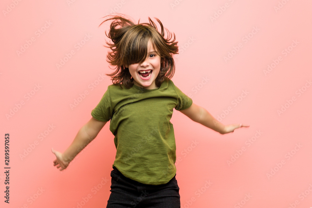 Little caucasian boy playing against a pink background - obrazy, fototapety, plakaty 