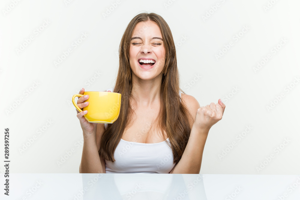 Young caucasian woman holding a cup cheering carefree and excited. Victory concept. Young caucasian woman holding a cup cheering carefree and excited. Victory concept.