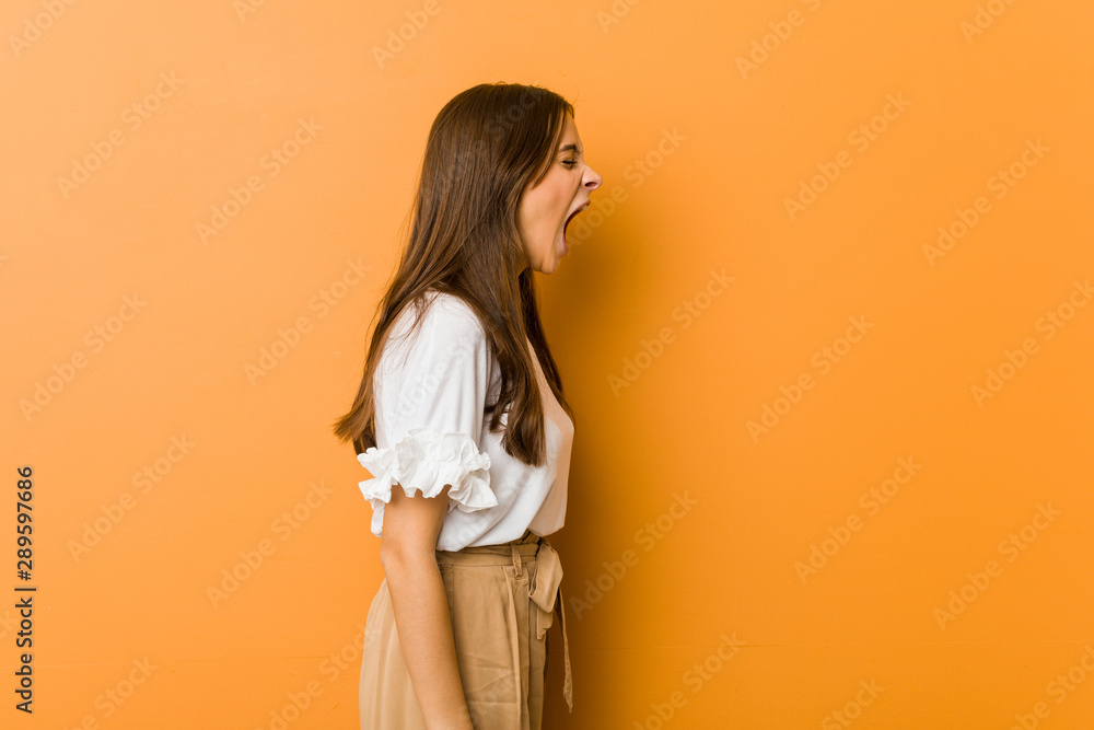 Young caucasian woman shouting towards a copy space Young caucasian woman shouting towards a copy space