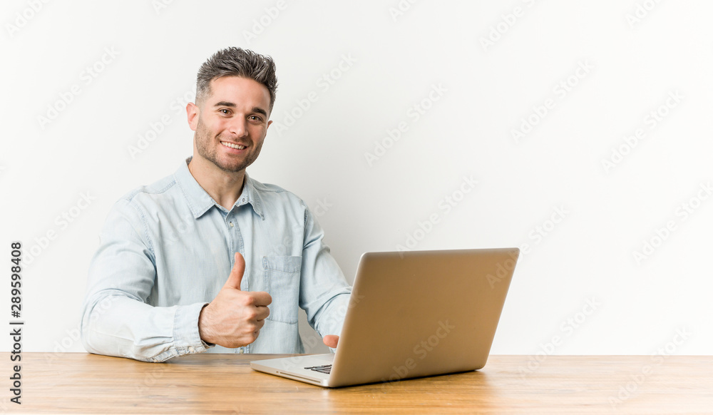 Young handsome man working with his laptop smiling and raising thumb up Young handsome man working with his laptop smiling and raising thumb up
