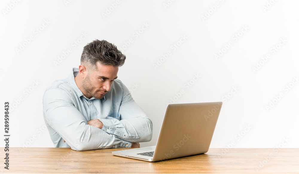 Young handsome man working with his laptop unhappy looking in camera with sarcastic expression. Young handsome man working with his laptop unhappy looking in camera with sarcastic expression.
