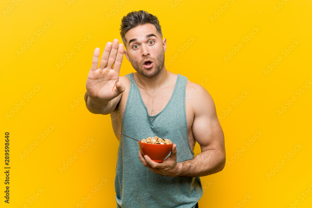 Caucasian man holding a cereal bowl standing with outstretched hand showing  stop sign, preventing you. Stock Photo | Adobe Stock