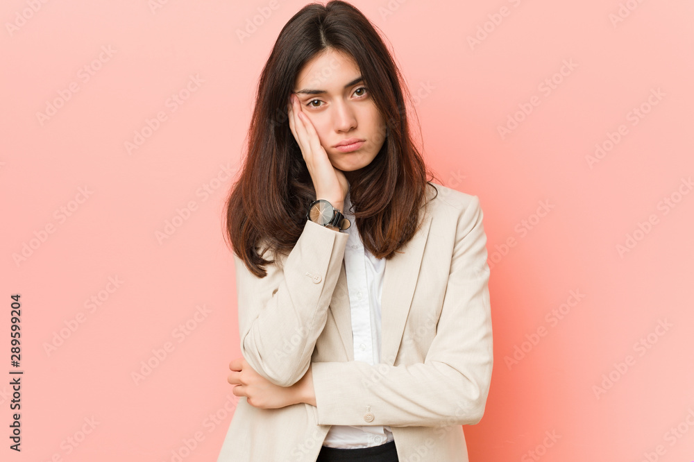 Young brunette business woman against a pink background who is bored, fatigued and need a relax day. Young brunette business woman against a pink background who is bored, fatigued and need a relax day.