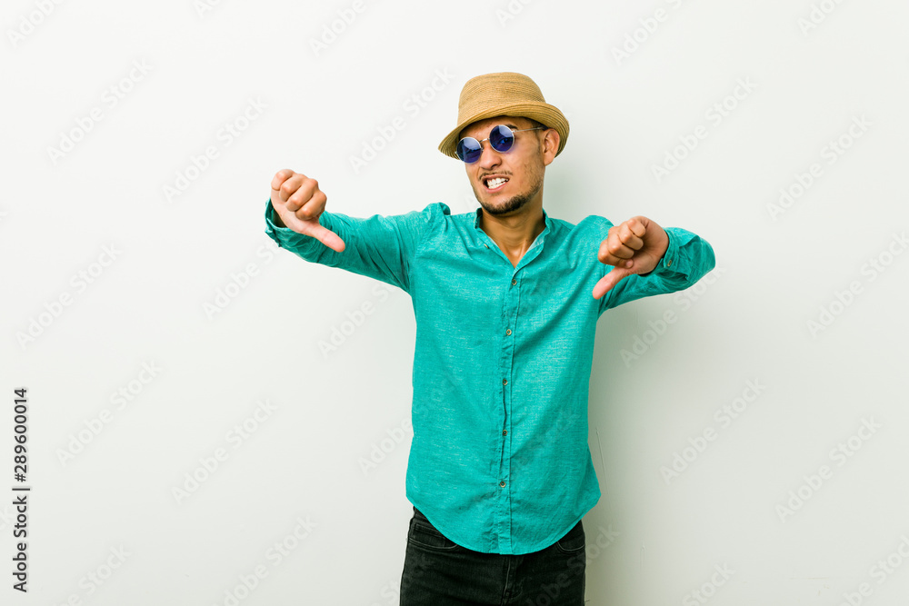 Young hispanic man wearing a summer clothes showing thumb down and expressing dislike.