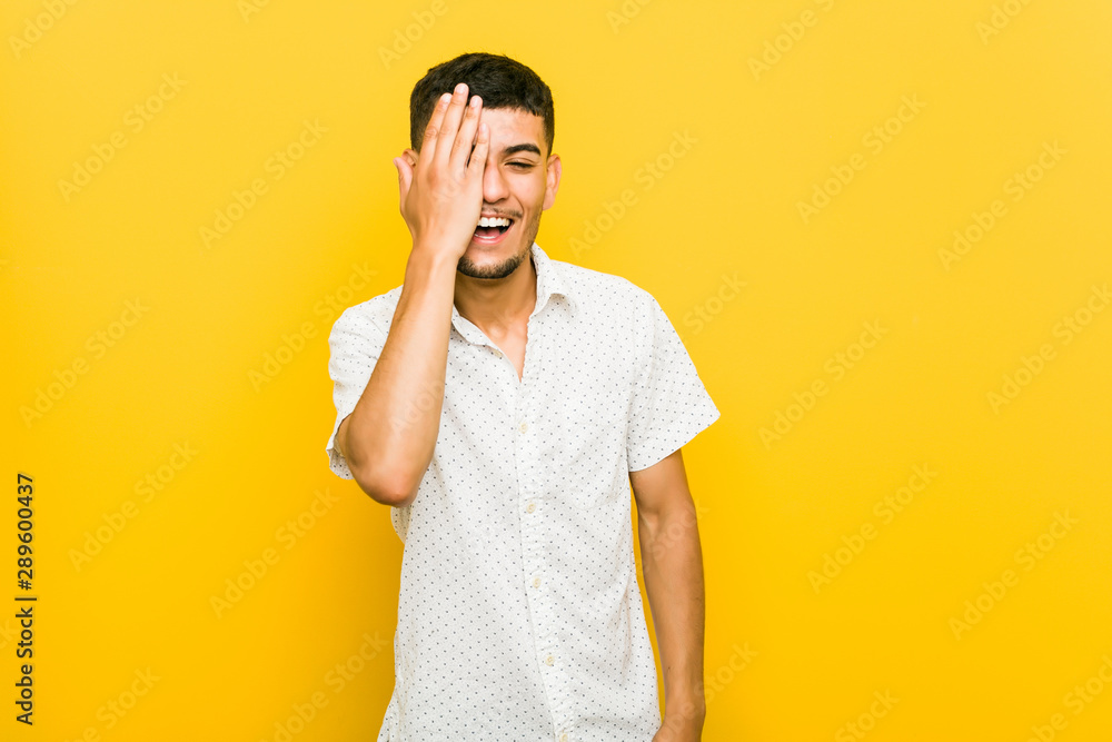 Young hispanic man having fun covering half of face with palm. Young hispanic man having fun covering half of face with palm.