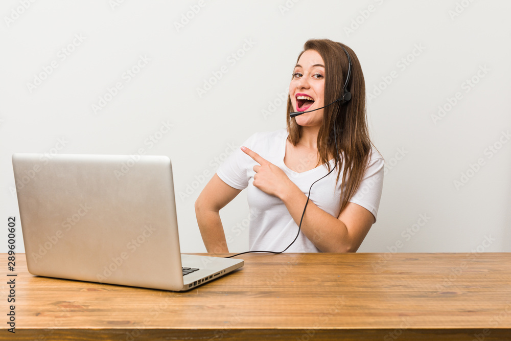 Young telemarketer woman smiling and pointing aside, showing something at blank space. Young telemarketer woman smiling and pointing aside, showing something at blank space.