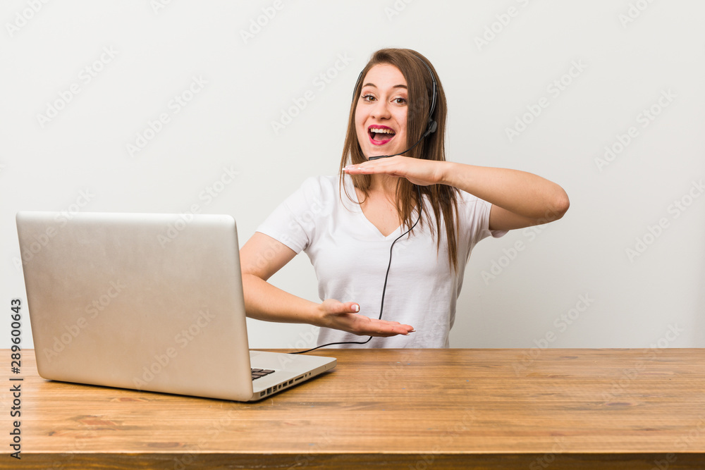 Young telemarketer woman holding something with both hands, product presentation. Young telemarketer woman holding something with both hands, product presentation.