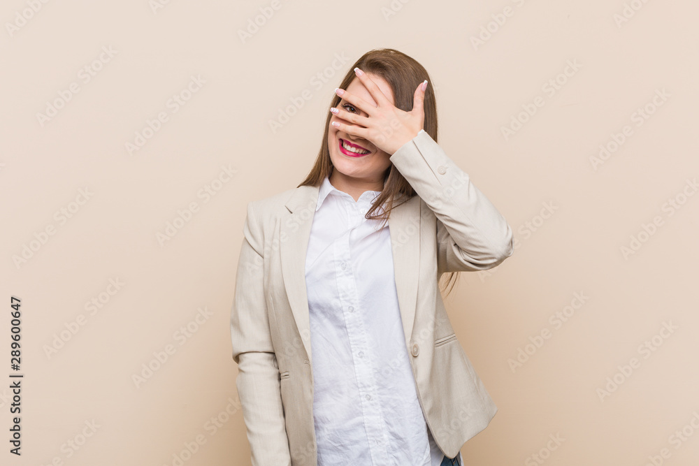 Young business woman blink at the camera through fingers, embarrassed covering face. Young business woman blink at the camera through fingers, embarrassed covering face.
