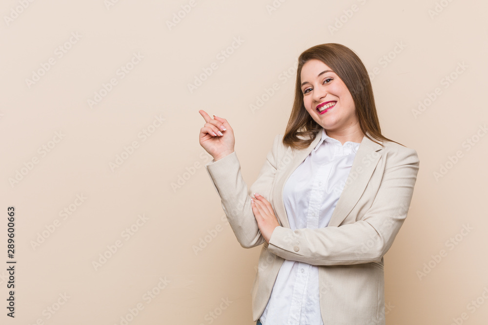 Young business woman smiling cheerfully pointing with forefinger away. Young business woman smiling cheerfully pointing with forefinger away.